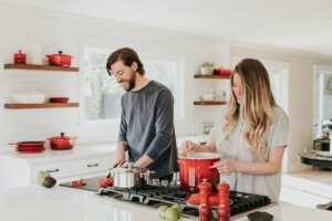 A man and woman preparing food in a kitchen.