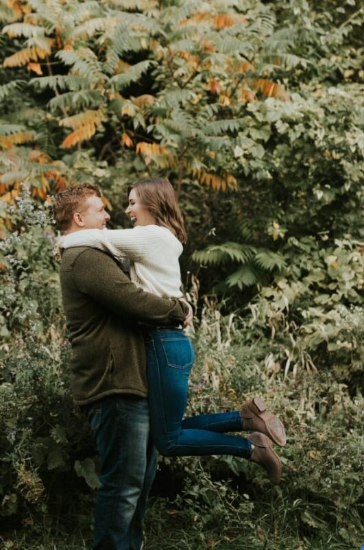 A couple hugging in the woods during their engagement session.