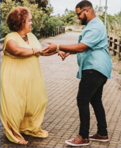 A man and woman dancing in a park.