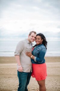 A couple posing for a photo on the beach.